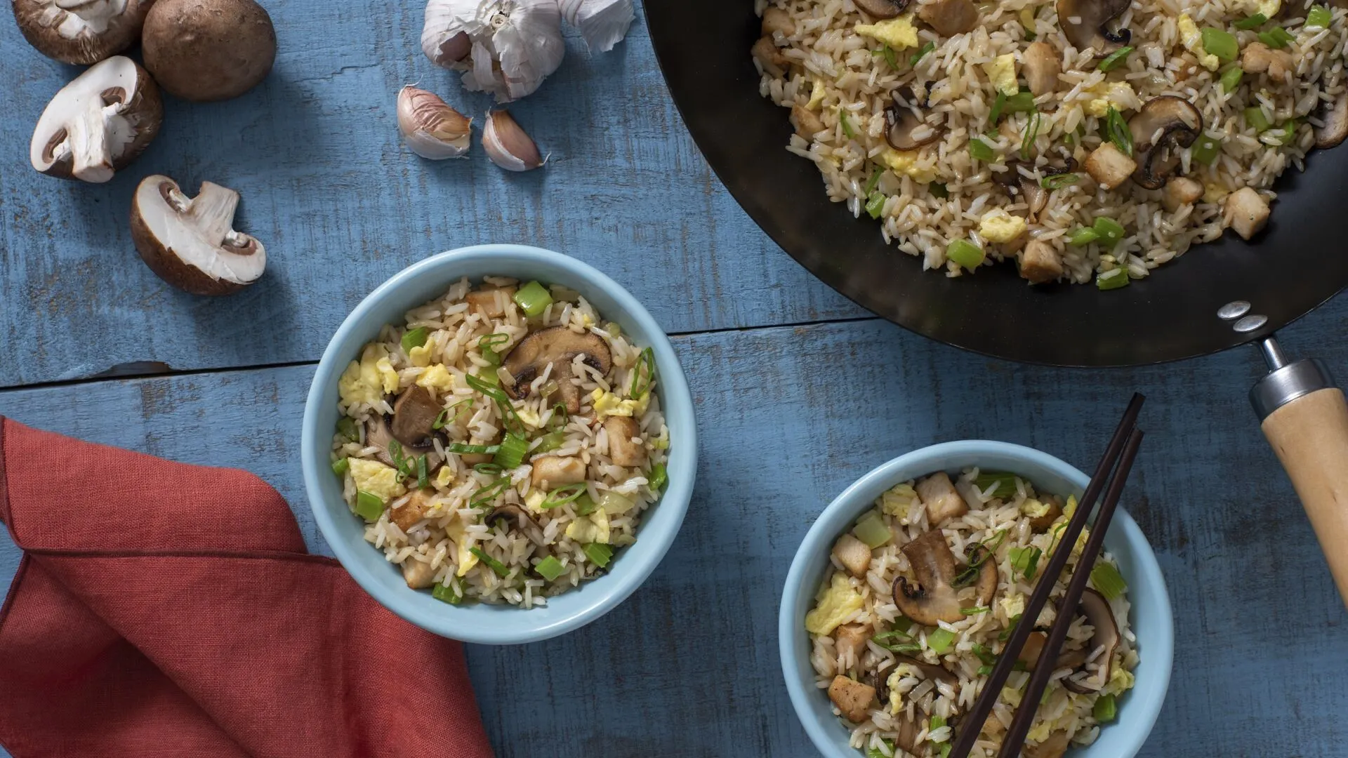 Chopsticks and bowl with fried rice, peas, shrimp and pork